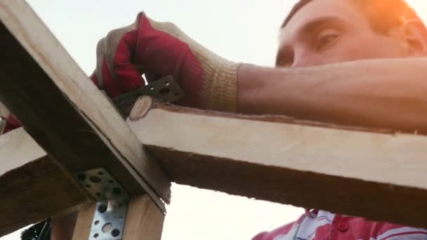 Worker drills of the roof structure on the sunset background. 3840x2160 — Stock Footage Worker drills of the roof structure on the sunset background. 3840x2160 Video Clip