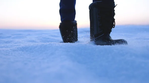 Male feet walking in deep snow. foot steps of hiker. recreational winter activity