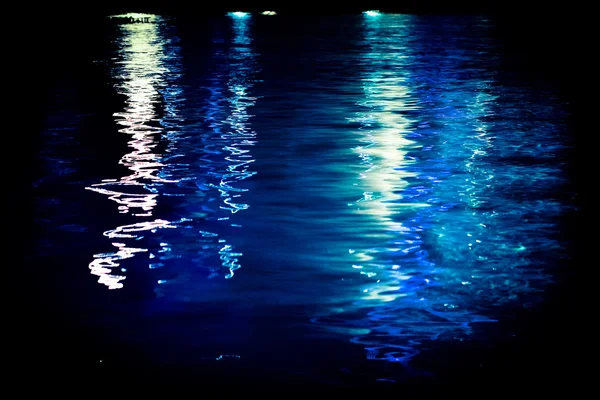 night landscape, sea, blue lights reflected in water