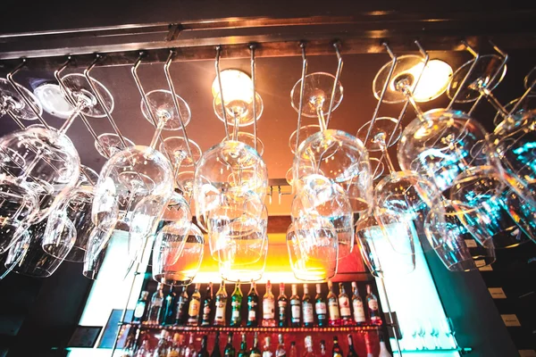 Empty glasses hanging at the bar and Bar with bottles Blurred Background — Stock Image Empty glasses hanging at the bar and Bar with bottles Blurred Background Royalty Free Stock Photos