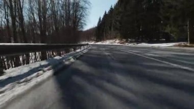Motorsikletten çekilmiş güneşli bir kış sokağı.
