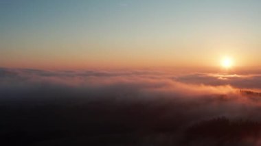 Güneşli sisli kış ormanı tepeleri gün batımında