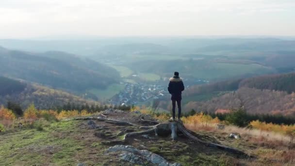 Ein Mann Steht Auf Einem Hügel Über Einem Mittelgebirge Gefilmt — Stockvideo