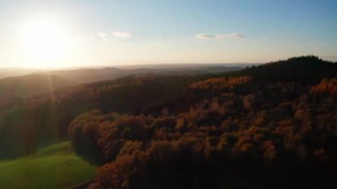 Ormanlık tepelerde akşam güneşi 4k 'de tepeden.