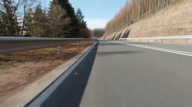 Bir motosiklet pov 'undan çekilmiş güneşli bir cadde.