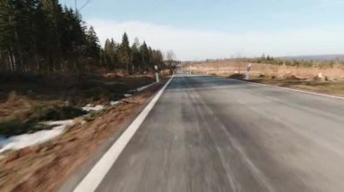 Motorsikletten çekilmiş güneşli bir kış sokağı.