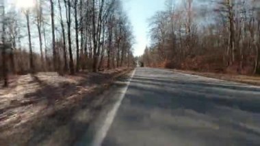 Motorsikletten çekilmiş güneşli bir kış sokağı.