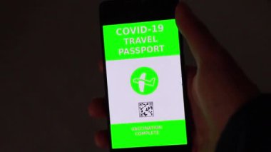 Akıllı telefondaki korona pasaportu kapalı alanda çekilmiş.