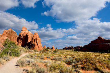 Utah 'taki Arches Ulusal Parkı' nda kızıl kayaların arasında yürüyüş yaparken..