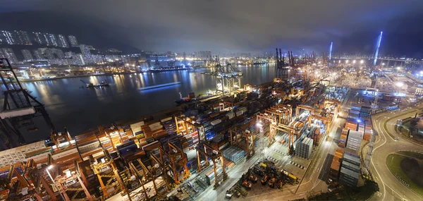 Lastfartyg och kranen på port reflektera över havet bay — Stockfoto