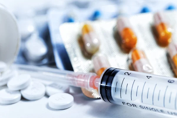 Syringe met glazen flesjes en medicijnen pillen drug — Stockfoto
