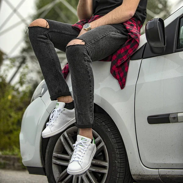 ミラノ イタリア 2017年10月4日 アディダス スタン スミスの靴を履いて白い車に座っている若い男 イラスト編集 ロイヤリティフリーのストック画像