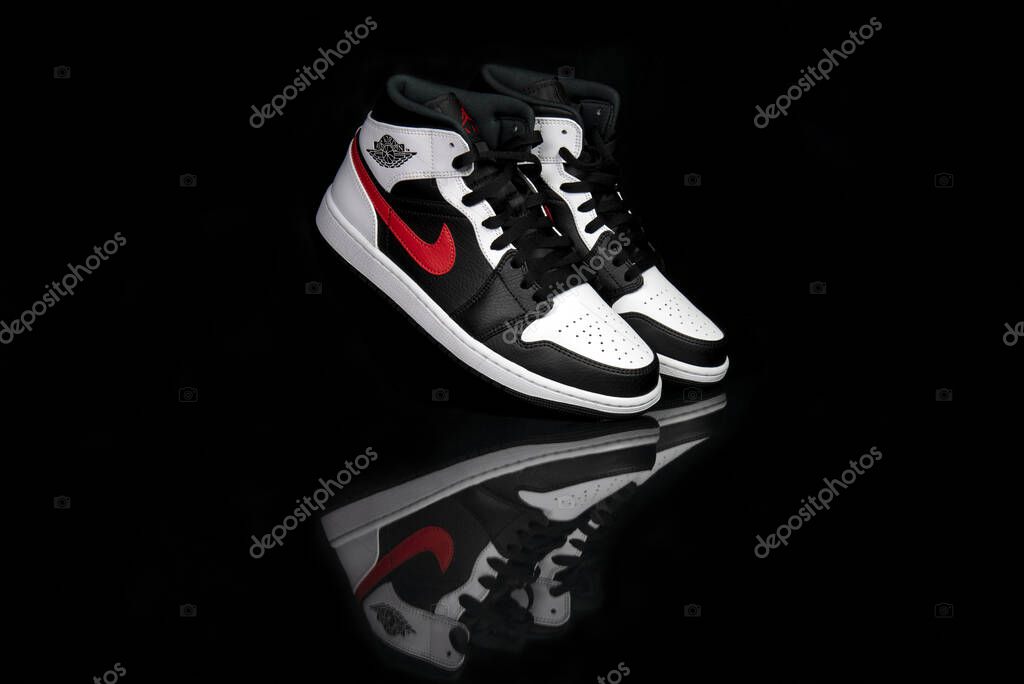 Pavia, Italy - November 2, 2020: Nike Jordan 1 Mid Black Chile Red White shoes studio shot - illustrative editorial