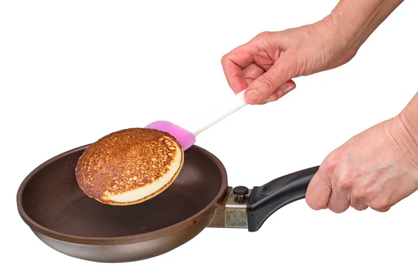 Hand flips a pancake in a frying pan — Stock Photo, Image