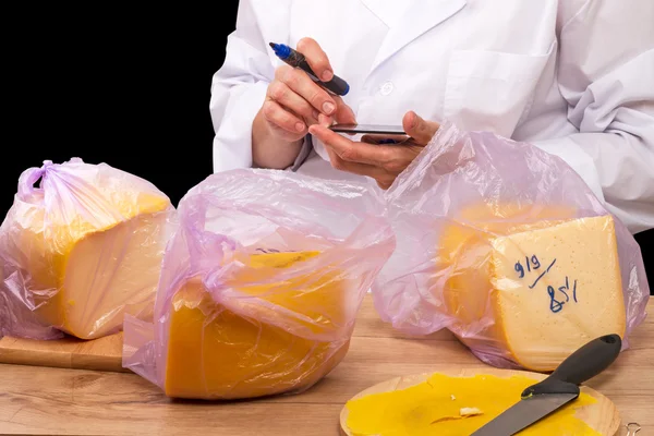Mujer con una calculadora y queso envasado — Foto de Stock