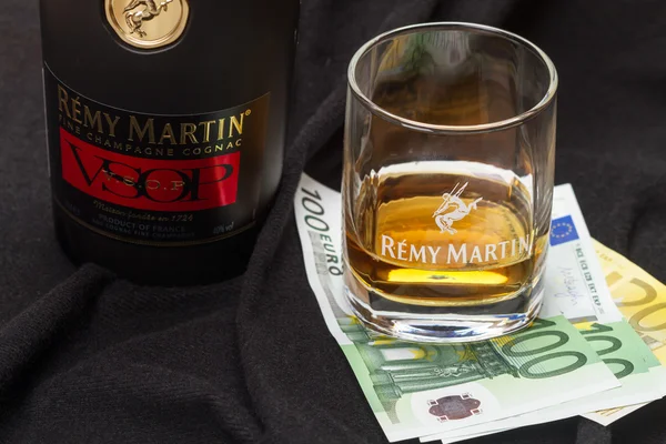 Glass cognac Remy Martin and euro banknotes — Stock Photo, Image