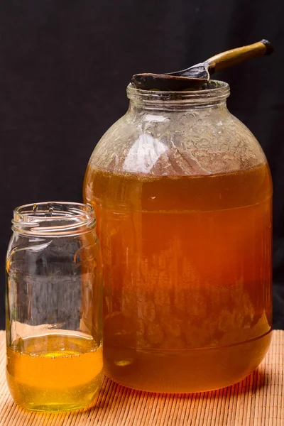 Grande vaso con miele e cucchiaio di legno — Foto Stock