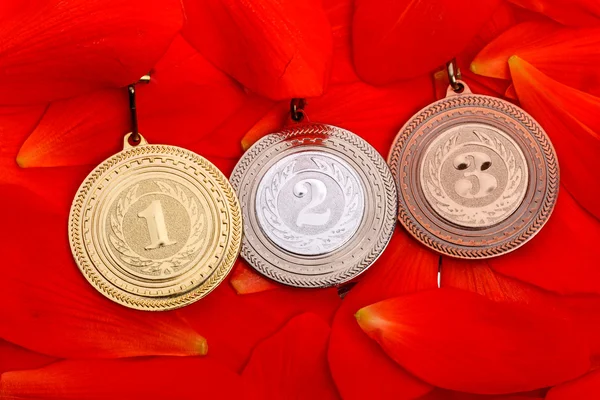 Sports medals on red petals — Stock Photo, Image