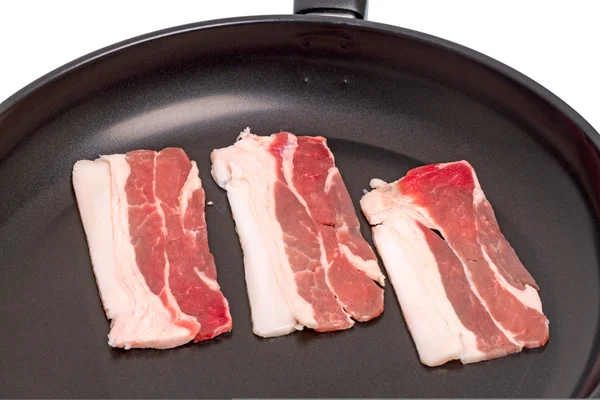 Pieces of bacon in a frying pan — Stock Photo, Image