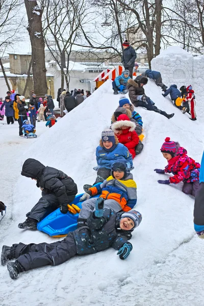 Bambini cavalcare con uno scivolo di neve — Foto Stock