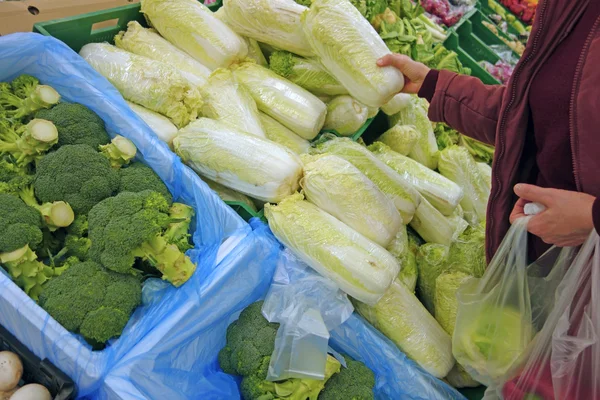 Napa and broccoli on store shelves — Stock Photo, Image
