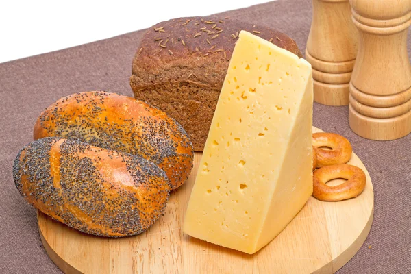 Productos de panadería y queso en una tabla de cortar — Foto de Stock