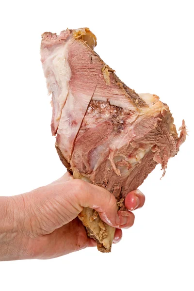 Cooked meat with a bone in his hand — Stock Photo, Image