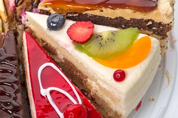 Pedazos de la torta con fruta fresca — Foto de Stock