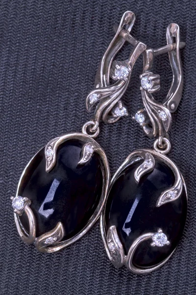 Silverörhängen med svart agat på tyg — Stockfoto