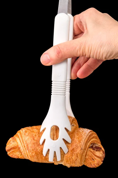 Cooking tongs and a croissant — Stock Photo, Image