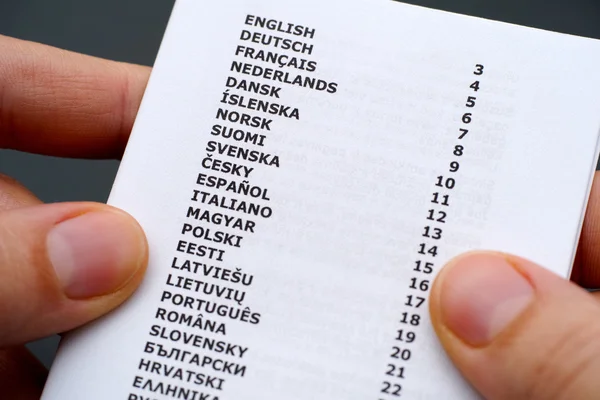 Booklet with list of languages in person hands — Stock Photo, Image