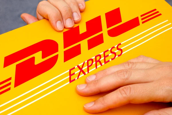 DHL Express pakiet w ludzkich rąk — Zdjęcie stockowe