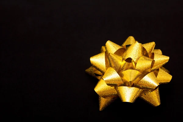 Golden bow on black background — Stock Photo, Image