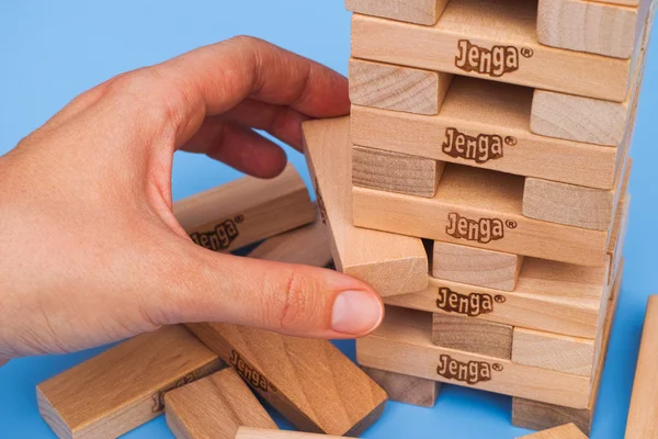 Παίκτης αφαίρεση μπλοκ από Jenga Πύργος κατασκευαστεί — Φωτογραφία Αρχείου