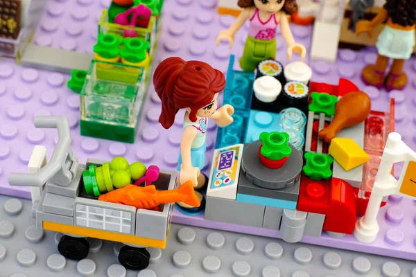 Lego-Mädchen mit Einkaufswagen im Supermarkt beim Gemüsewiegen — Stockfoto