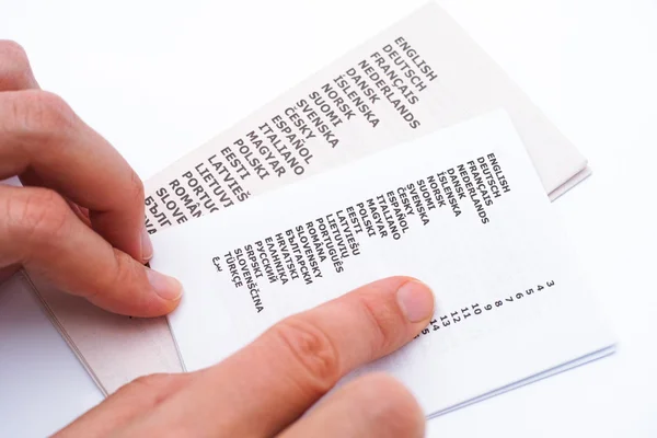 Booklet with list of languages and woman hands — Stock Photo, Image