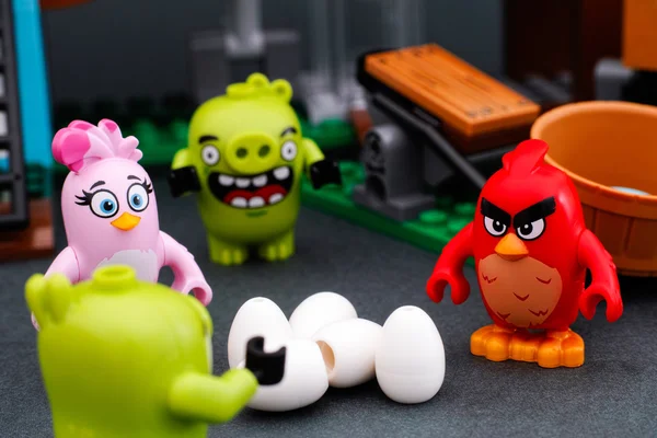 Lego Angry Birds. Красный, Стелла и 2 поросёнка стоят рядом с 5 яйцами — стоковое фото