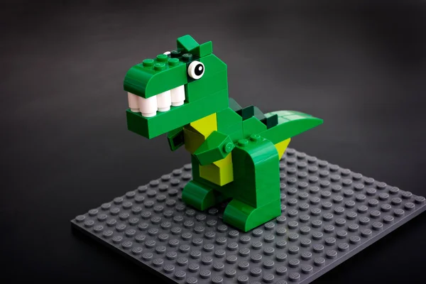 Juguete de dinosaurio verde Lego en placa base gris — Foto de Stock