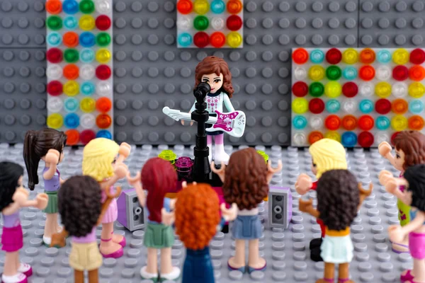 Lego friends girl minifigure with electric guitar and audience — Stock Photo, Image