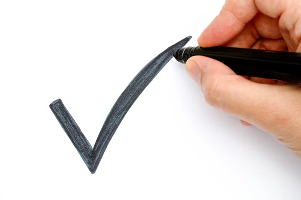 Woman hand with marker drawing black check mark — Stock Photo, Image