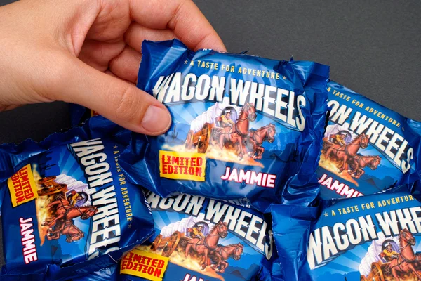 Woman hand with Jammie Wagon Wheels cookie — Stock Photo, Image