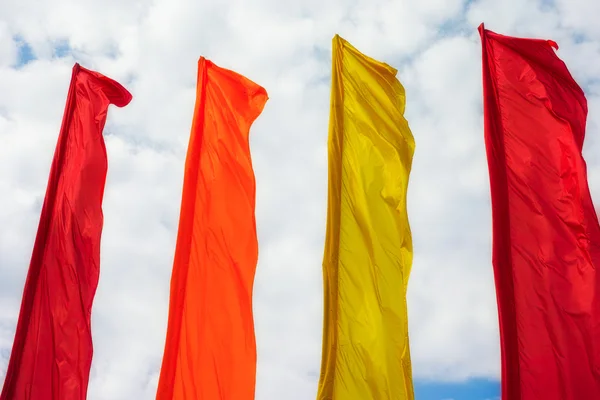 Ряд разноцветных флагов против облачного неба — стоковое фото
