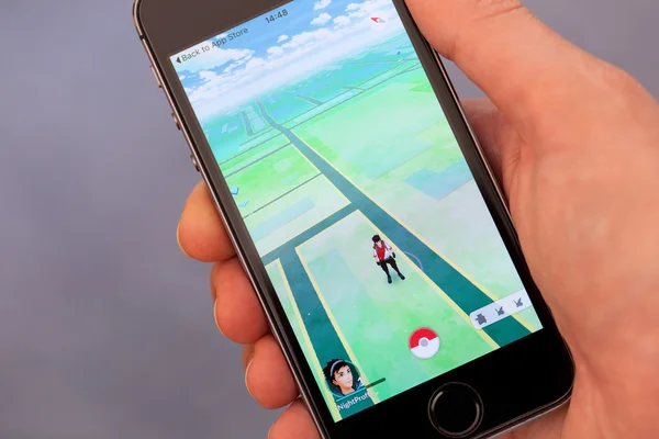 Person Hand spielen Pokemon Go Anwendung auf Apple iphone — Stockfoto