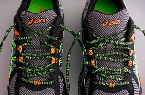 Asics snickers mit grünen Schnürsenkeln — Stockfoto