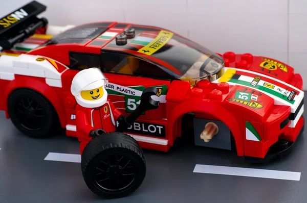 Lego minifigura motorista é roda de fixação de Ferrari 458 Italia GT — Fotografia de Stock