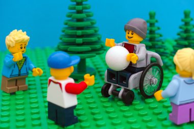 Lego çocuk parkında arkadaşlarıyla top oynarken tekerlekli sandalyede