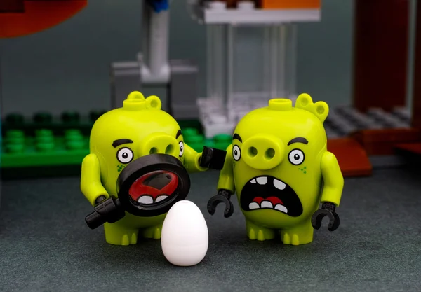 Dos cerditos malos Lego con lupa y huevo — Foto de Stock
