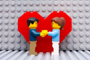 Lego çift ayakta kalp önünde