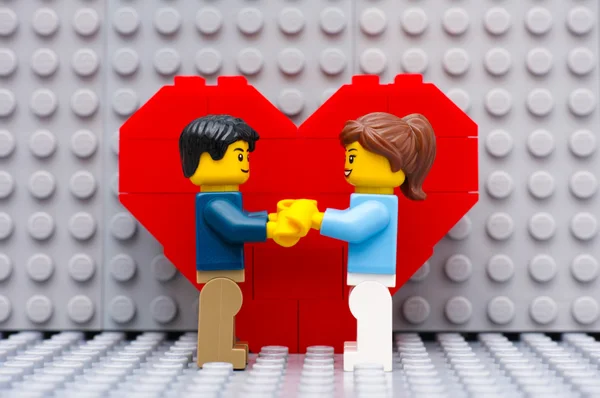 Lego casal de pé na frente do coração — Fotografia de Stock