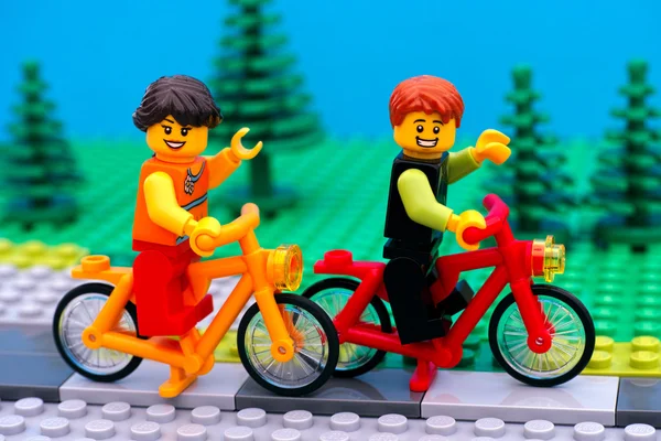 Lego boy and girl riding bikes in park — Stock Photo, Image